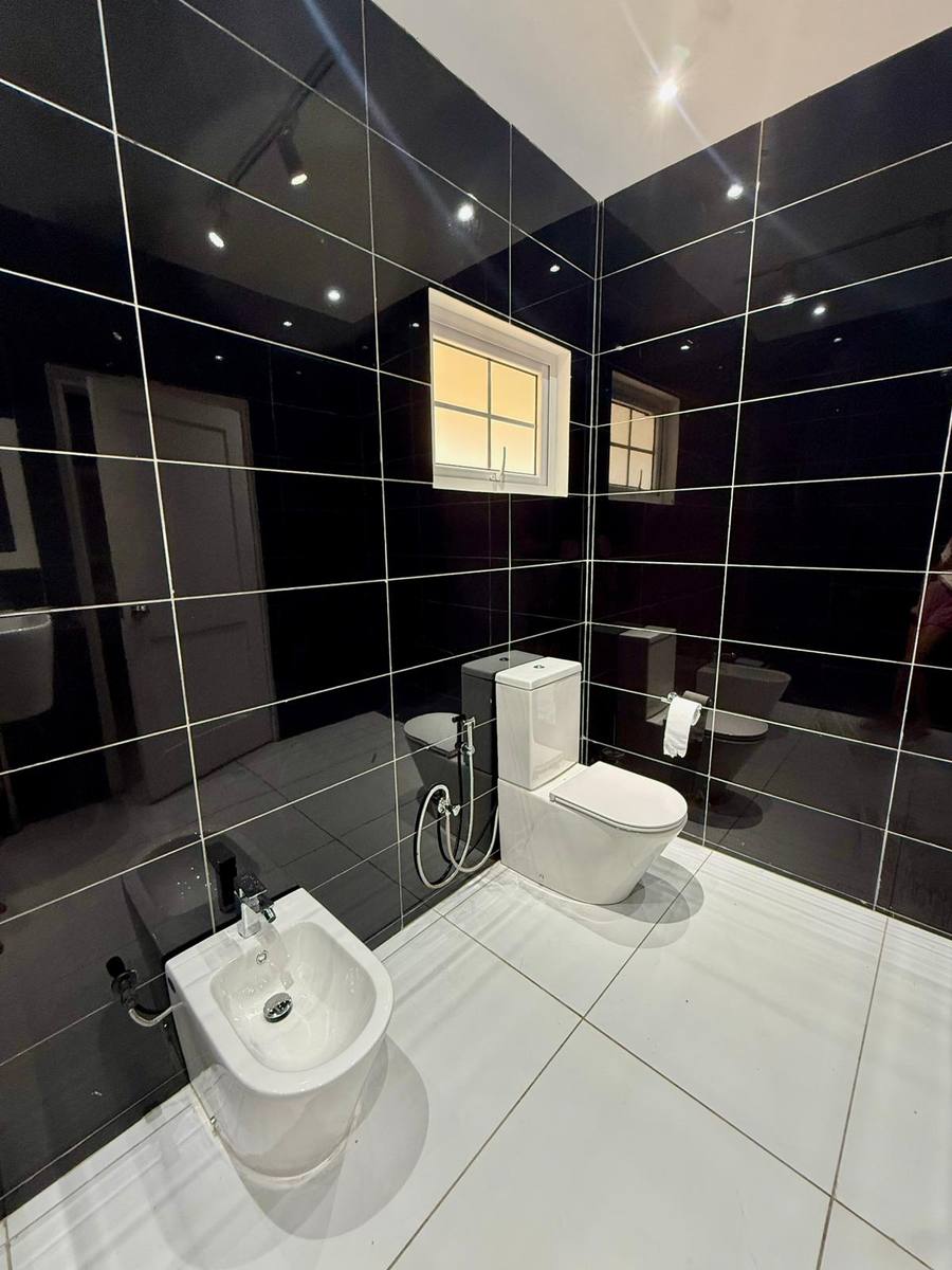 The black-tiled second bath